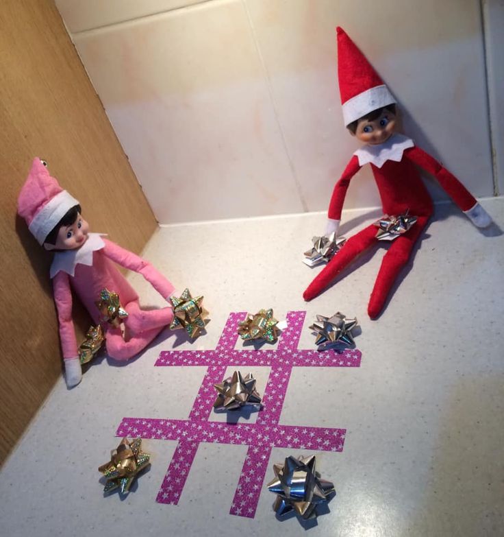 two elf dolls sitting next to each other on the floor