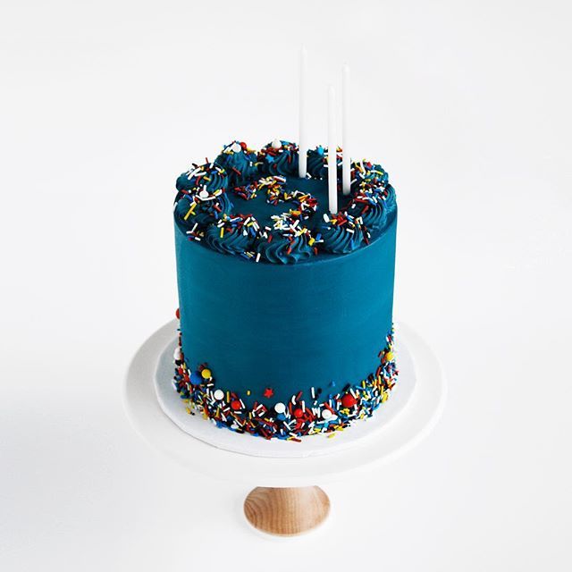 a blue birthday cake with sprinkles and candles