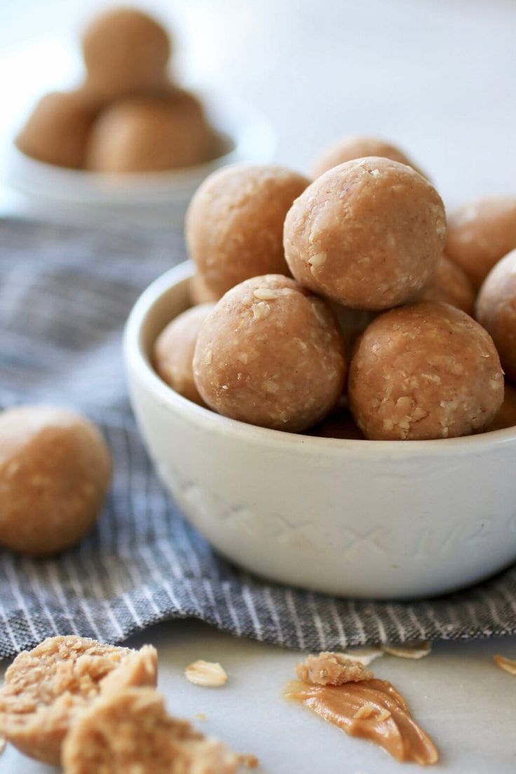 a white bowl filled with peanut butter balls on top of a blue and white towel