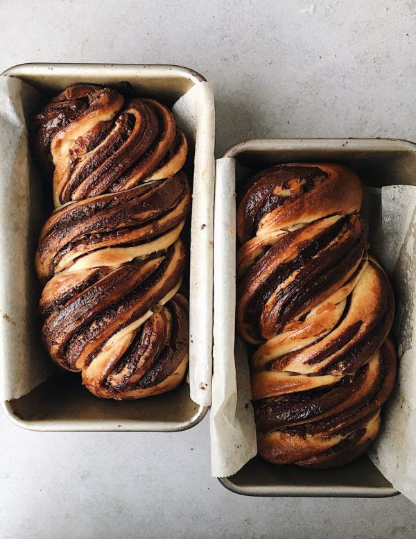 two loafs of bread sitting on top of pans covered in chocolate swirled dough