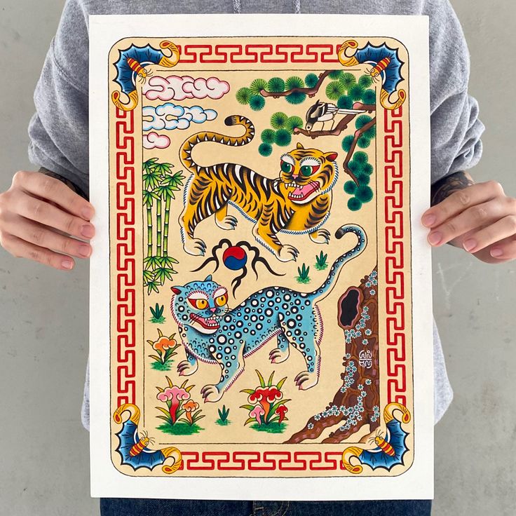 a person holding up a painting with tigers on it