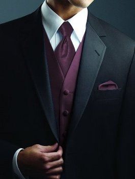 a man wearing a suit and tie with his hands in his pockets