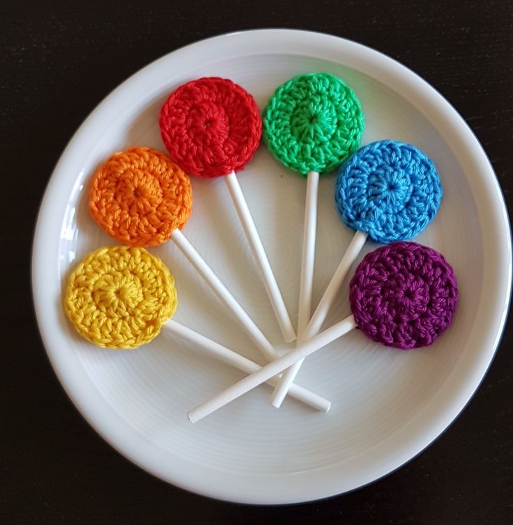 crocheted lollipops on a white plate