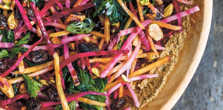 a wooden bowl filled with lots of veggies and other things on top of it