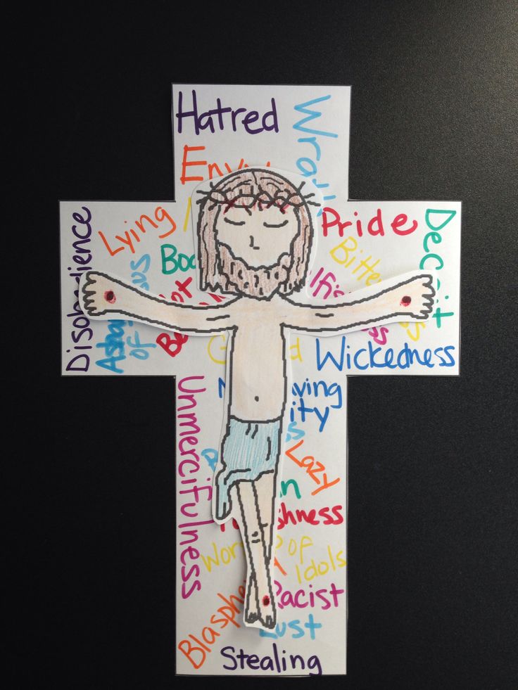 a cross made out of paper with words written all over it and a person on the cross