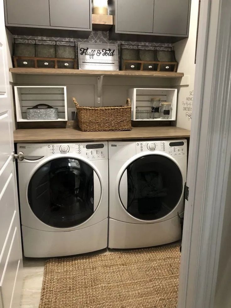 a washer and dryer in a small laundry room with baskets on the shelves