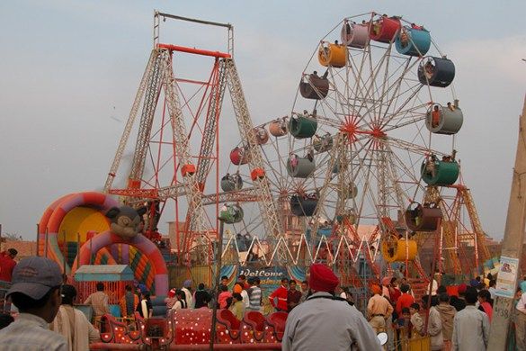 an amusement park with many rides and people walking around