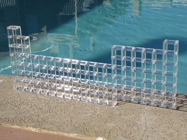 clear plastic blocks sitting on the edge of a swimming pool