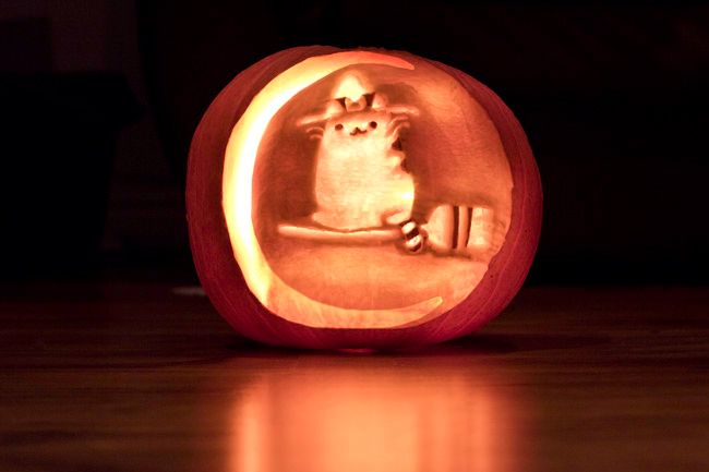 a carved pumpkin with an image of a cat on it's face in the center