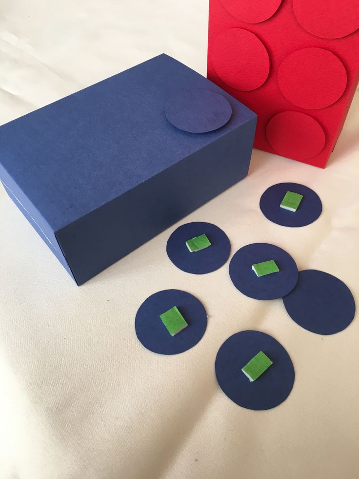 several pieces of blue and green paper are next to a red box