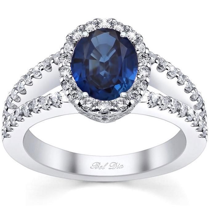 The split shank band of this engagement ring setting is encrusted with pristine G color VS clarity white diamonds that run up to the halo, which is itself set with diamonds to surround the lavish AAA quality oval blue sapphire center stone. This sparkling split shank acts like a runway that spotlights the center stone Nails Almond Yellow, Blue Sapphire Engagement Ring Halo, Sapphire Halo Engagement Ring, Blue Sapphire Jewelry, Yellow Diamond Engagement Ring, Blue Clothes, Split Shank Engagement Rings, Sapphire Engagement Rings, Silver Linings