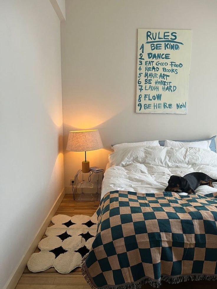 a dog laying on top of a bed next to a night stand and two lamps