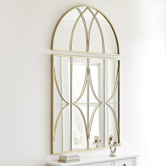 a mirror on the wall above a white dresser with drawers and an ornate gold frame