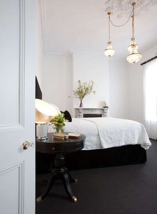 a bedroom with white walls and black flooring