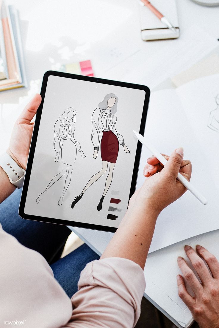 a woman is holding an ipad with drawings on it