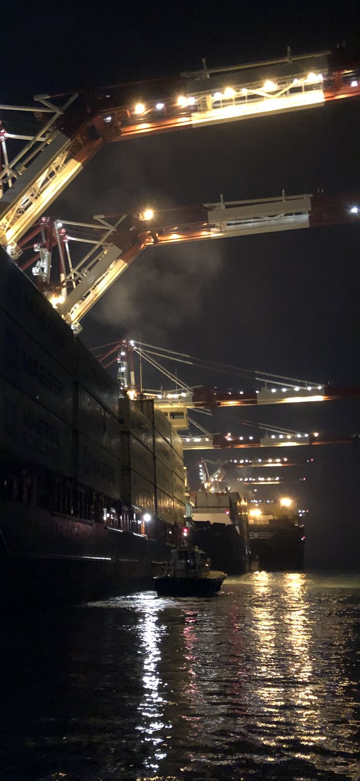 a large cargo ship docked at night with lights on