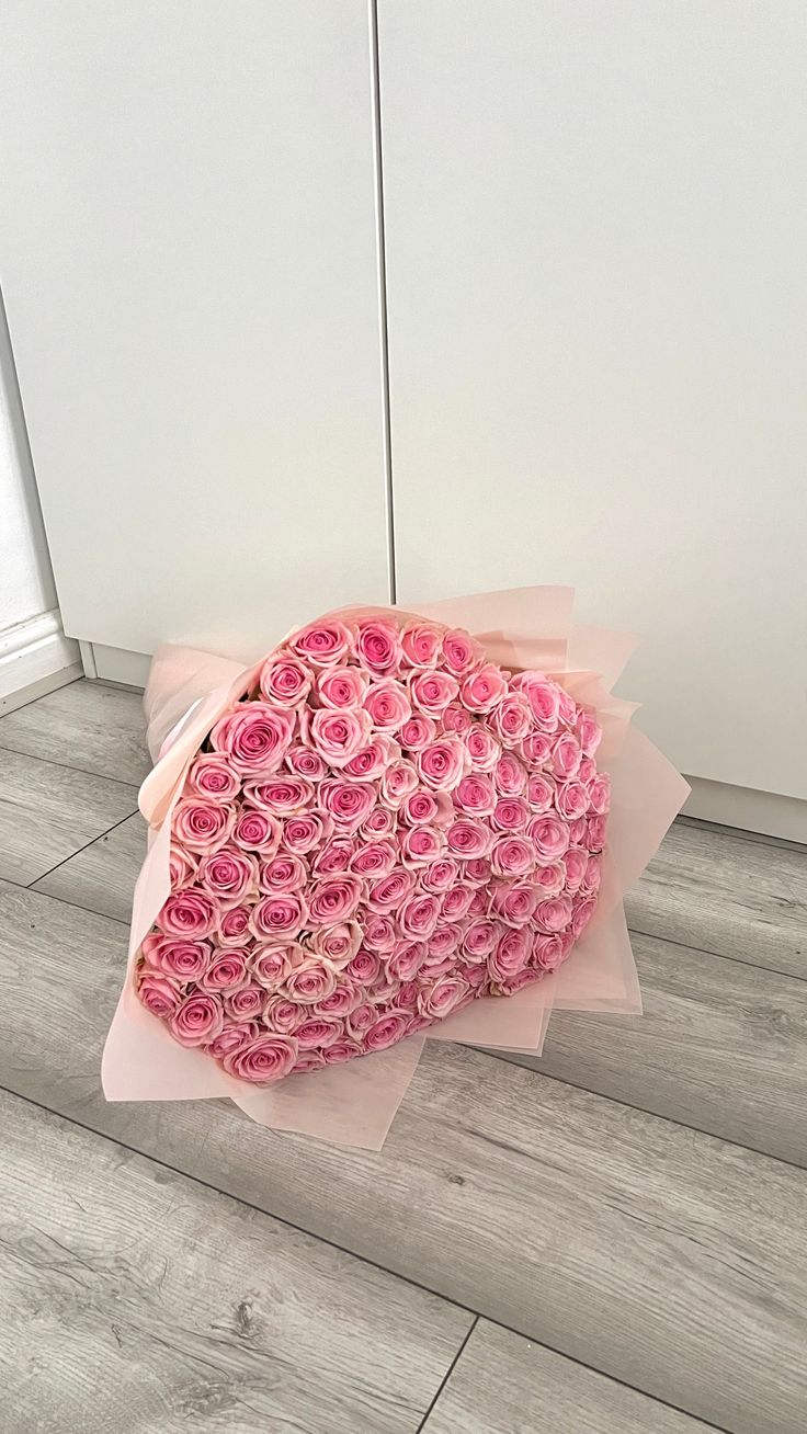 a large bouquet of pink roses is on the floor