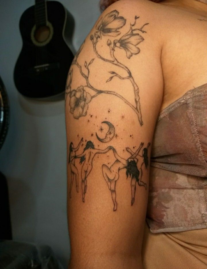 a woman with a cow tattoo on her arm and shoulder is standing in front of a guitar