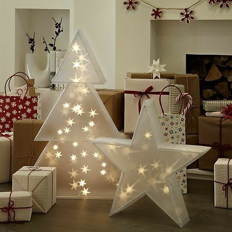 a christmas tree surrounded by presents in front of a fire place and decorated with stars