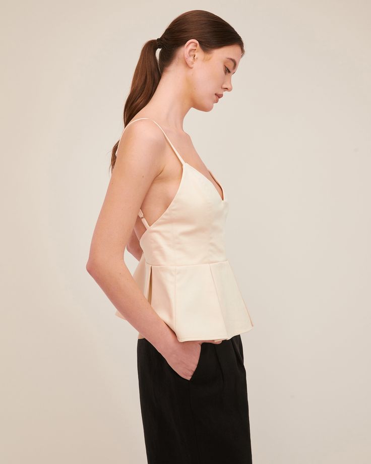 The Emily top offers a flattering fitted waist with an easy open back. The peplum hem is updated with structured pleating details. Dress the Emily down with denim or pair her with the Solea Linen Wide Leg Trouser for an elegant and refined look for a night out. Fitted at bust and empire Bodice lined in self fabric Back fly zipper closure Adjustable shoulder straps with adjustable back strap Pleated peplum 64% Cotton, 31% Nylon, 5% Spandex Model is 5’10” and wearing a size S.This style runs large Marissa Webb, Peplum Hem, Back Strap, Shoulder Straps, Open Back, Peplum Top, Bodice, Night Out, Wide Leg