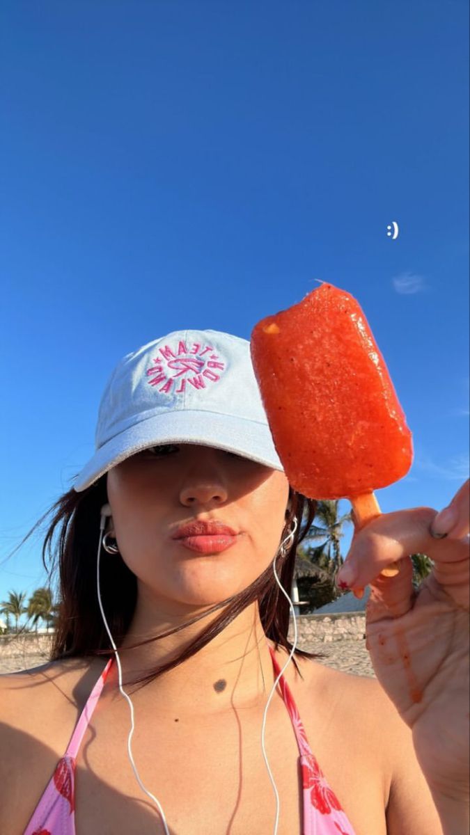 a woman wearing headphones holding up a piece of fruit