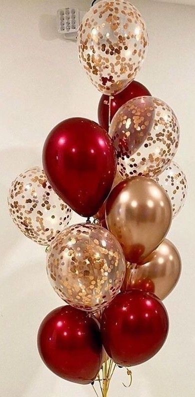 a bunch of red and gold balloons in a vase