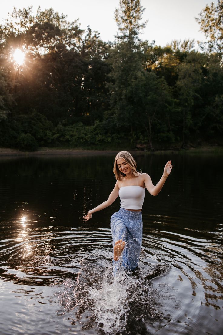 a woman standing in the water with her arms outstretched