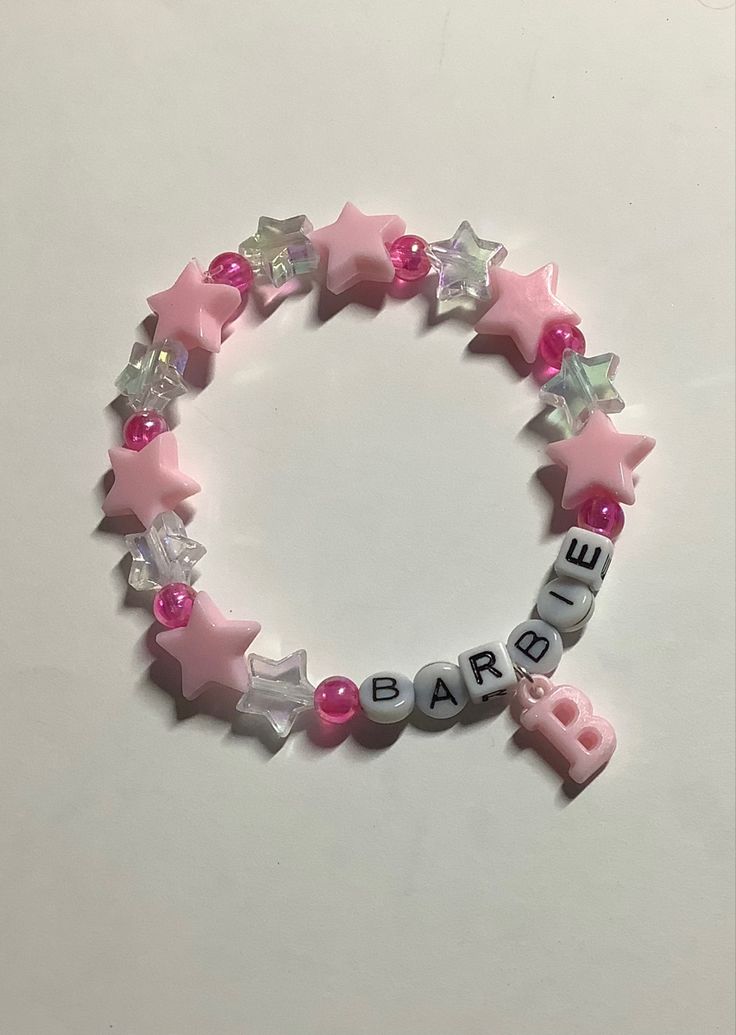 a pink bracelet with stars and letters on it