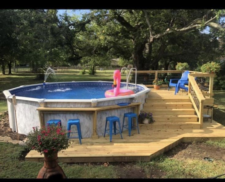 an above ground pool with steps leading up to it and blue stools on the deck