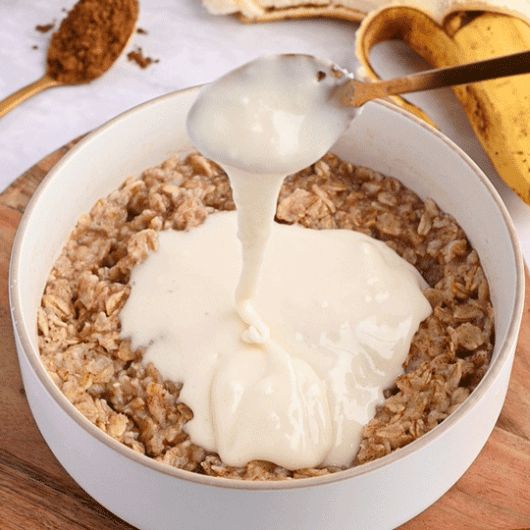 a bowl of oatmeal is being drizzled with milk