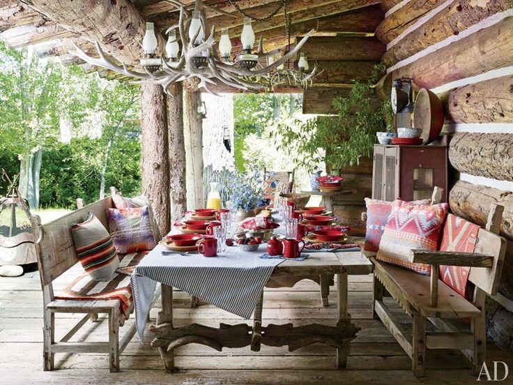 an outdoor dining area with lots of furniture and decor on the outside wall, including a table