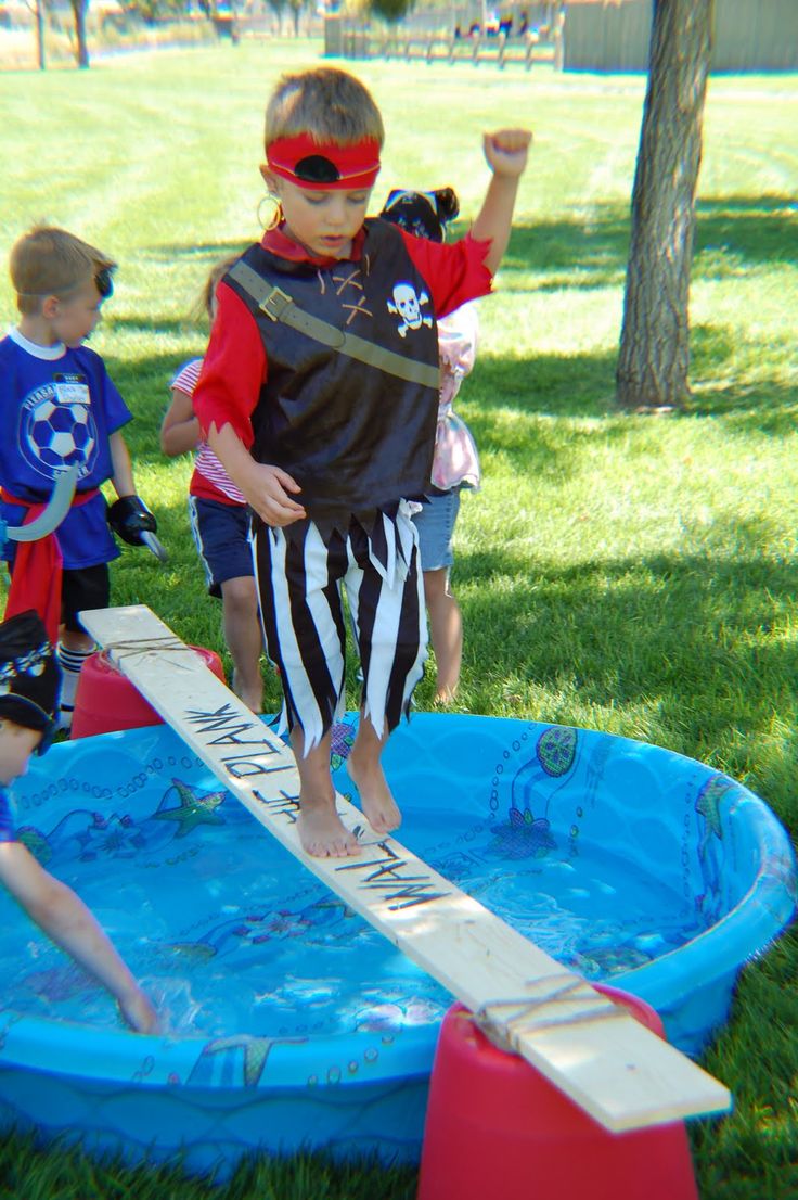 a little boy standing on an inflatable pool