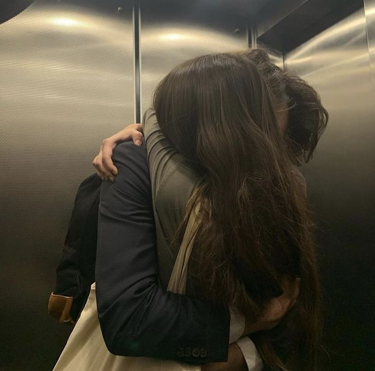 two people hugging each other in an elevator