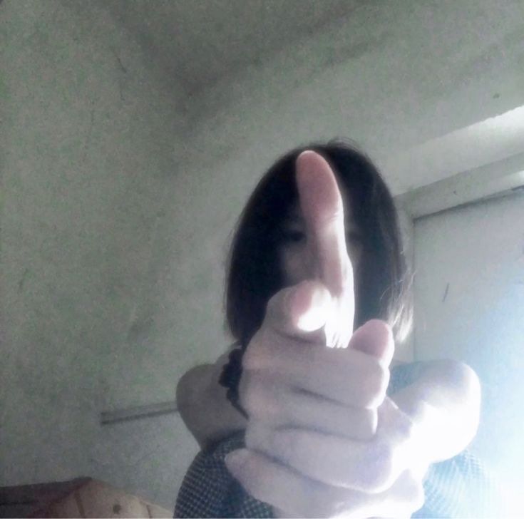 a woman giving the thumbs up sign in front of her face