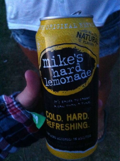 a person holding up a can of cold hard refreshing beer in their left hand, with the caption mike's hard lemonade