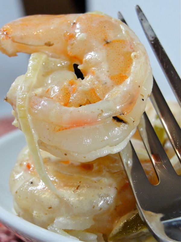 the shrimp is being served in a bowl with utensils and sauce on it