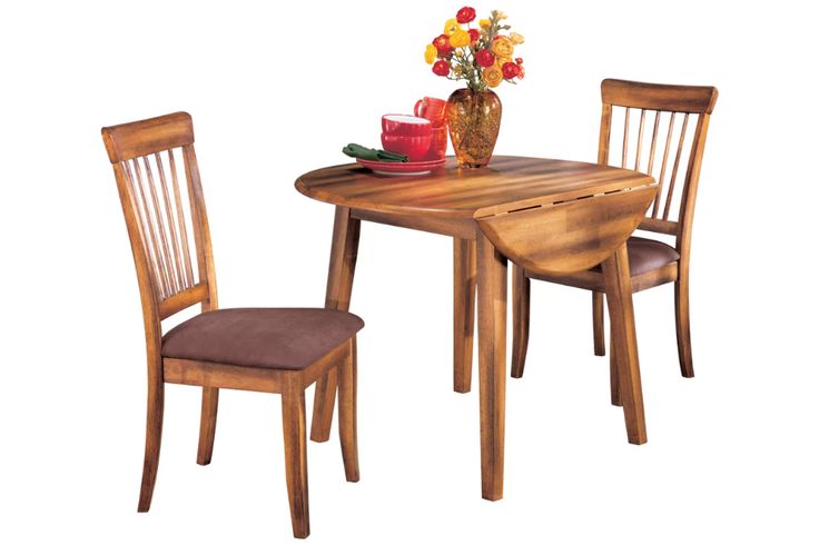 a wooden table with two chairs and a vase filled with flowers on top of it