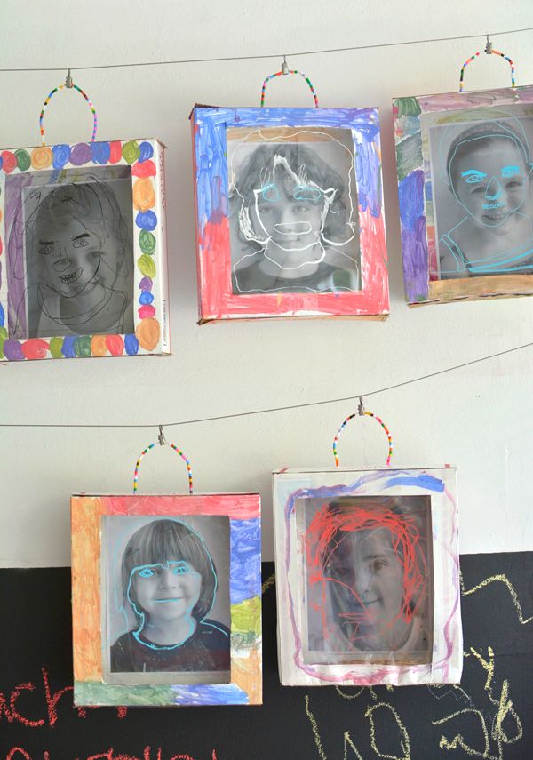 four frames are hanging on the wall with pictures and string lights strung from them to create an art project