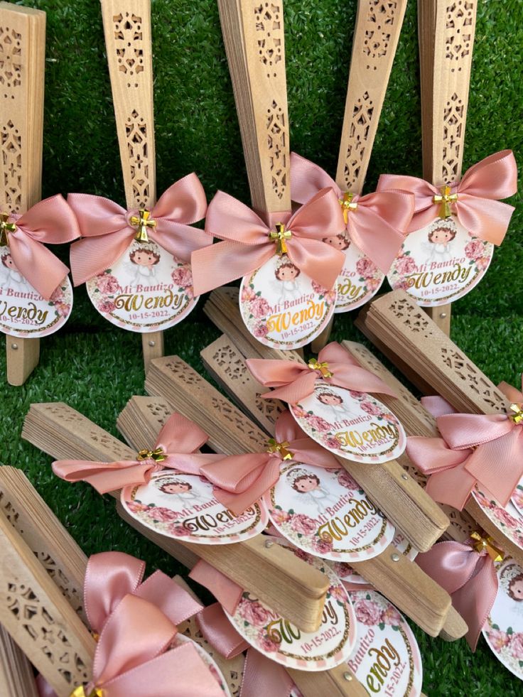 many wooden pieces with pink bows on them are arranged in the shape of heart tags