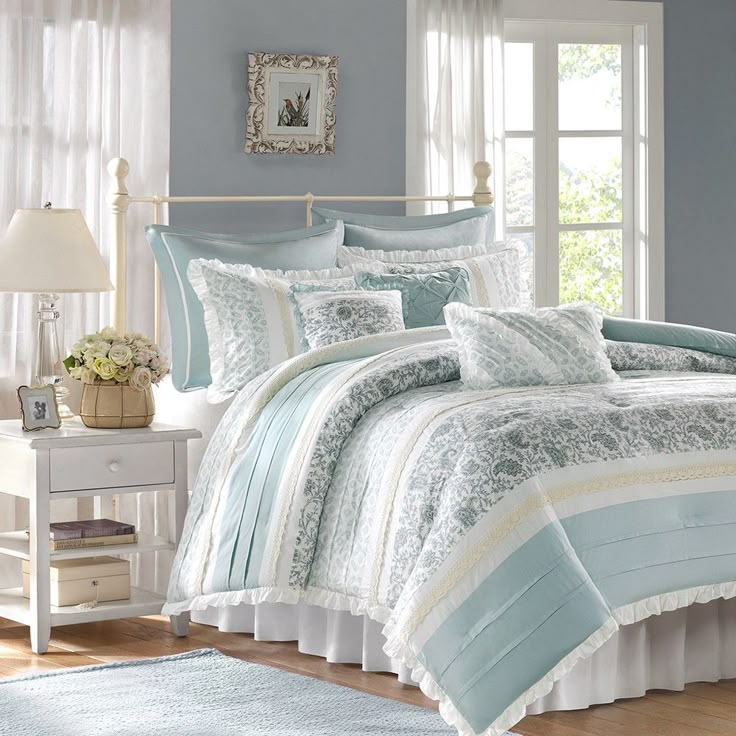 a bed with blue and white comforters in a room