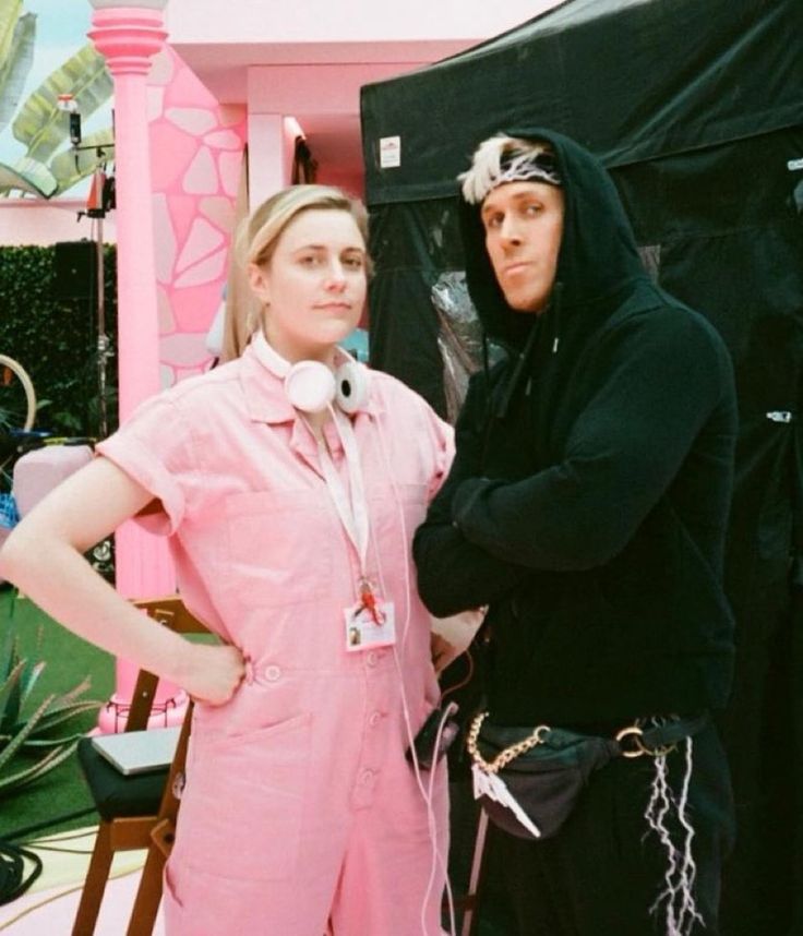 two women standing next to each other in front of a black and white tent with pink walls