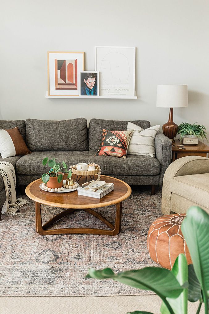 a living room with couches, tables and pictures on the wall above it that says tour boho colorful living room