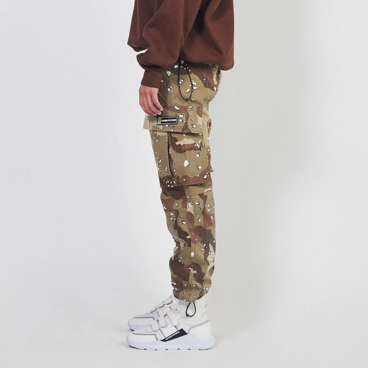 - 100% desert camo print cotton denim- Daniel Patrick branded button front closure with zip fly- Belt loop waist- Utility pockets with velcro closure- Daniel Patrick motorsport rubber label at left thigh- Adjustable bungee cord at ankleSlightly oversized fit. For a more regular fit, we recommend taking one size down.Male model is 6' 1" and wears a size Medium.Female model is 5' 8" and wears a size X-Small. Rubber Label, Daniel Patrick, Fit Cargo Pants, Usa Sweatshirt, Camo Cargo Pants, Desert Camo, Utility Pockets, Fall Wear, Bungee Cord