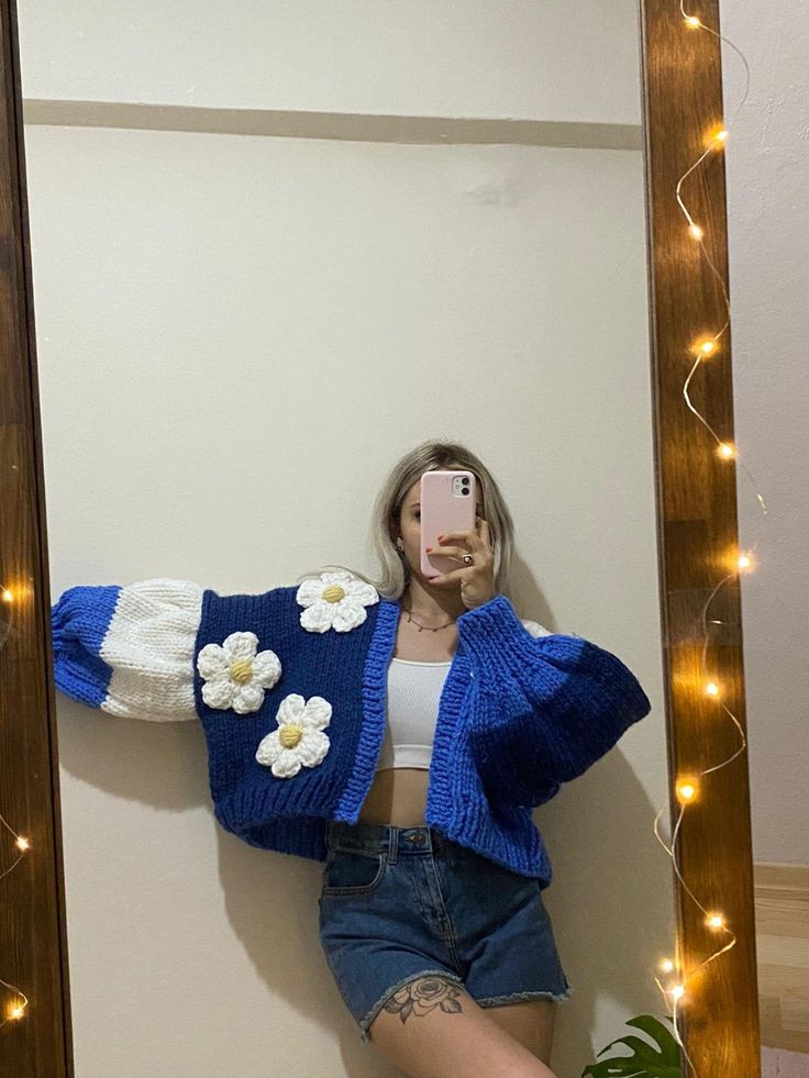 a woman is taking a selfie in front of a mirror with flowers on it