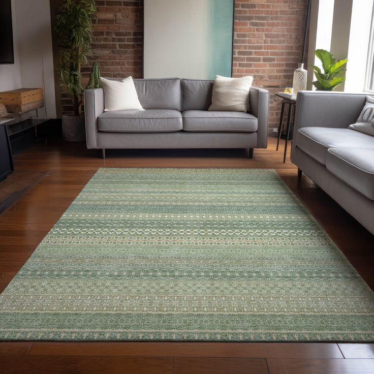 a living room filled with furniture and a large rug on top of a hard wood floor