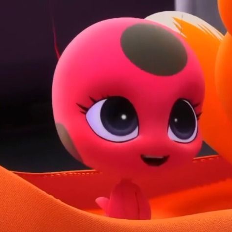 a close up of a toy with big eyes and an orange object in the background