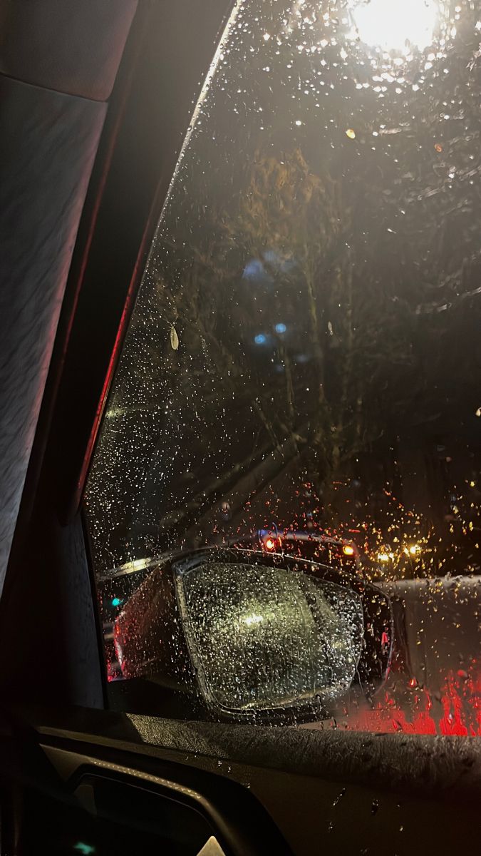 rain is falling on the windshield of a car