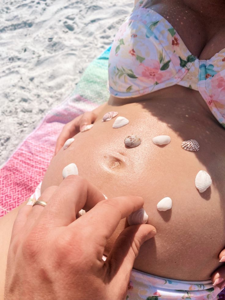 a pregnant woman with seashells on her belly