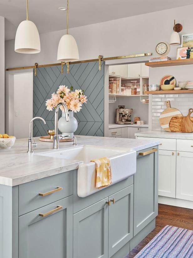 a kitchen with blue cabinets, white counter tops and yellow accents on the wall above the sink