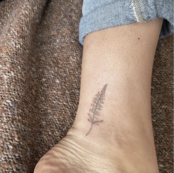 a woman's foot with a small flower tattoo on her left side calfocks